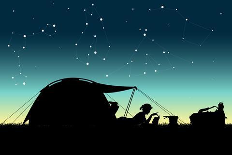 A silhouette of a woman in a tent with the night sky behind