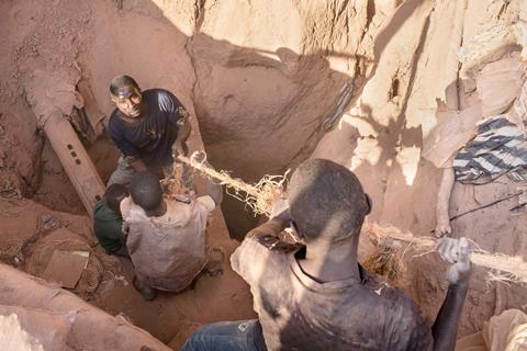 Men and boys working in a hole in the ground