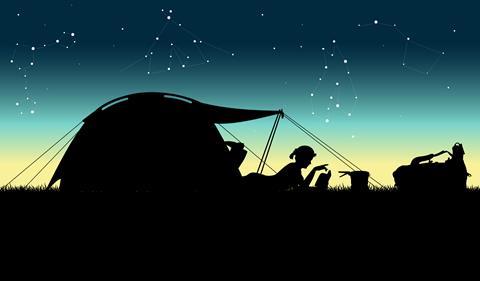 A silhouette of a woman on a camping trip against a starry sky