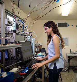 Catherine Masoud operates a chemical ionisation mass spectrometer in one of the test house's adjacent trailers