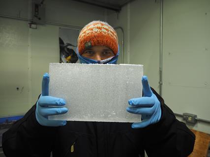 An image showing a researcher processing ice core samples in a lab kept at temperatures below freezing