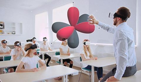 A teacher and students all wearing VR headsets examine an electron shell orbital diagram in 3d