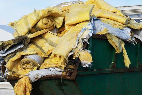A pile of waste home insulation in a skip