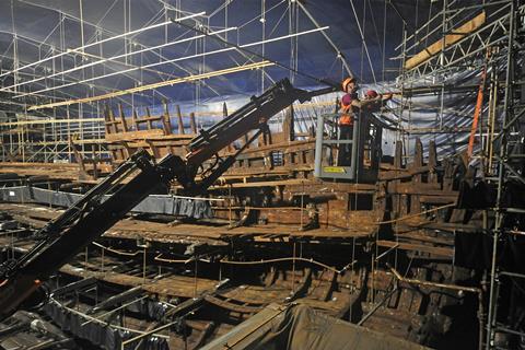 Men working on a wooden shipwreck