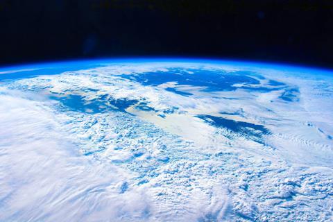A photo of the Earth from orbit showing the thin blue atmosphere and white clouds
