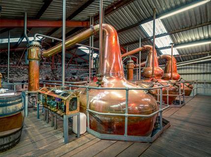 Whisky distillery in a warehouse, large brass stills