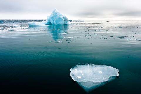 Arctic sea ice floating in green blue sea