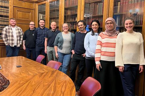 The RSC Education publishing editorial board stood up in front of bookshelves in an old library.