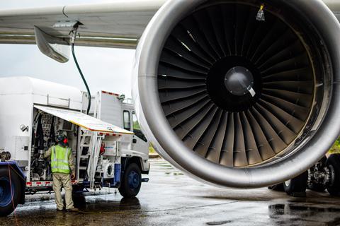 Van with person in hi-vis refueling a jet engine