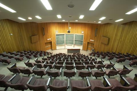 An image showing an empty auditorium or lecture theatre, shot from the back at the top looking down to the lecturer's position