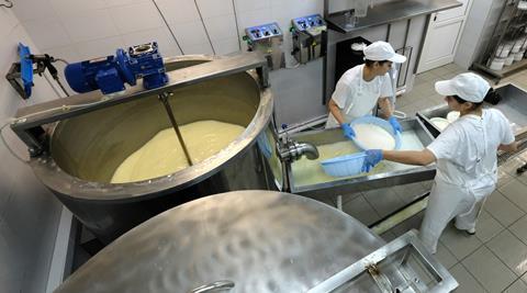 An image showing two women making cheese