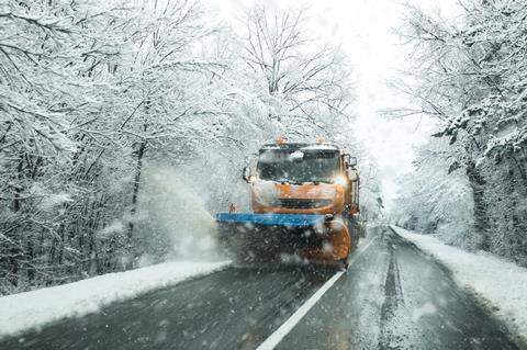 A snow plough clearing snow from a road
