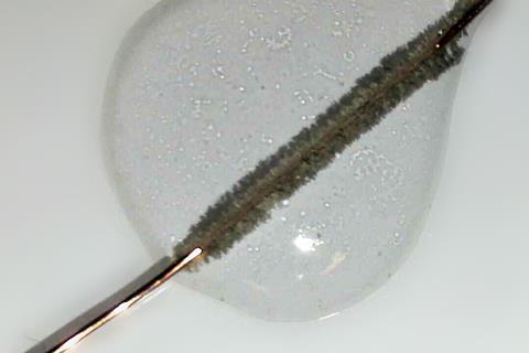 A copper wire going furry in a droplet