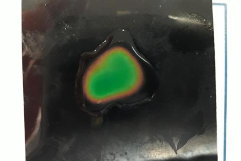 A droplet of water with a green centre and orange edge
