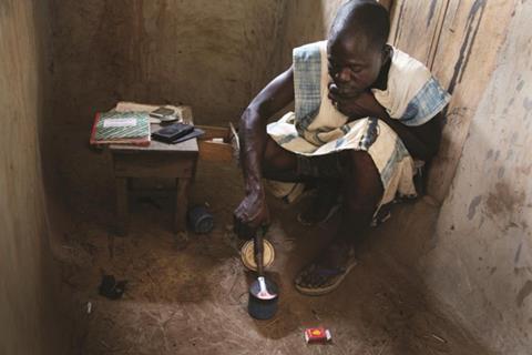 A gold buyer burning off mercury used to extract the gold from muddy water