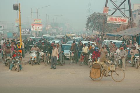 New Delhi rush hour, vehicles and pedestrians at a crossroad