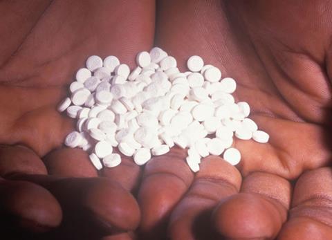 Hands holding white pills
