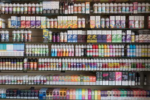 Different brands and flavours of vape juice on a shop shelf