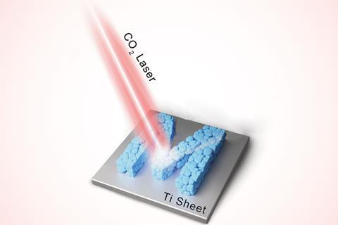 A carbon dioxide laser targets an M made of squished blue blobs on a Titanium sheet