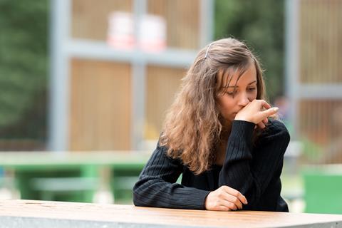 Girl sitting at a table with a look of regret