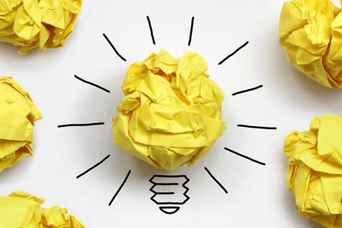 Screwed up piece of yellow paper with lines to make it look like a lit lightbulb