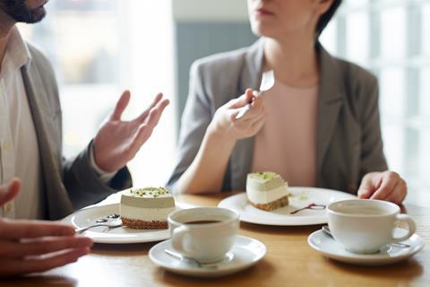 Professionals chatting over coffee and cake