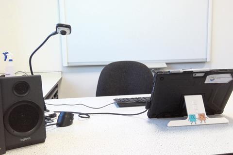 A teacher's desk with a tablet computer and webcam