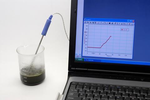 A beaker of dark green bubbling liquid with condensation forming on the side had a temperature probe reporting into a laptop which shows a line graph of the temperature increasing