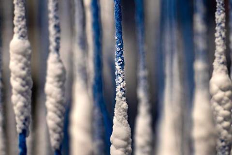 Blue strings hanging down with a white salt crystallizing on them