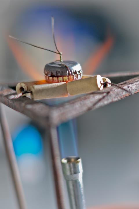 Two bottle tops in a bunsen burner flame