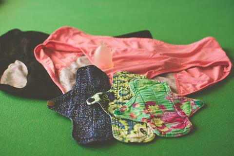 A photo of washable period pads and pants, and a menstrual cup