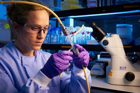 An engineer working with tubes and equipment in a lab