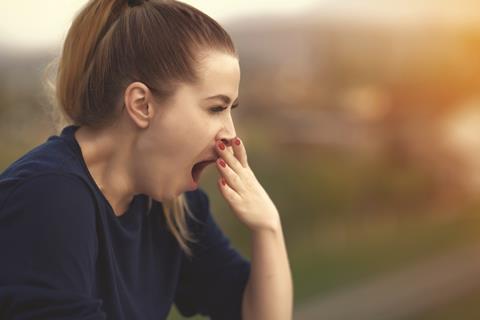 Woman yawning outdoors