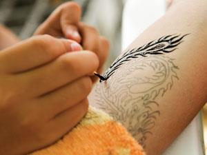 An artist applies a tattoo to skin