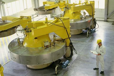 A photo of a worker with large yellow and silver industrial equipment