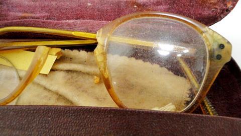 A close up photo of an old broken pair of glasses