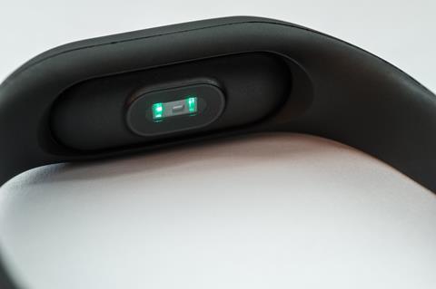A photo of the back of a smart watch showing the green lights and the sensor
