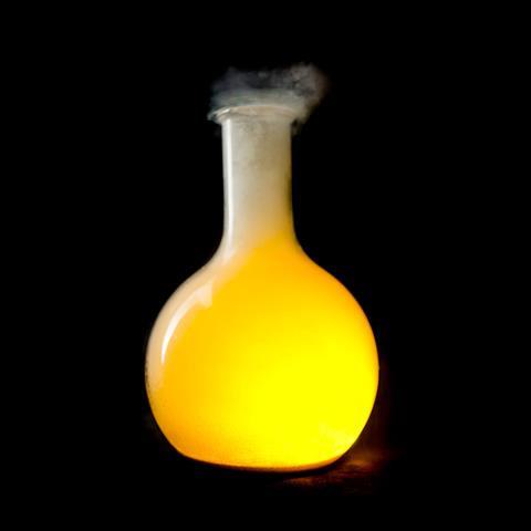 A bright yellow glow and smoke in a glass flask in a lab
