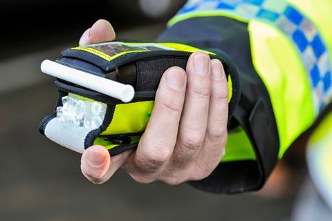 A police officer's hand holding a breathalyser