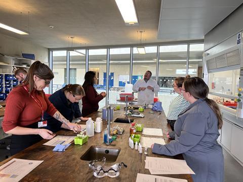 A group of people carrying out a practical experiment in a lab