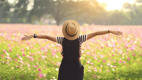 A woman with her arms out in the sun