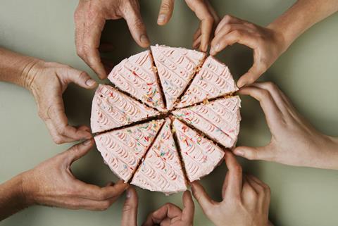 A picture showing a pink-iced cake, cut into eight, a hand going to pick up each piece