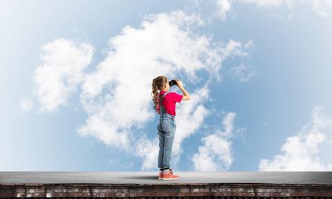 Girl looking into the sky with binoculars