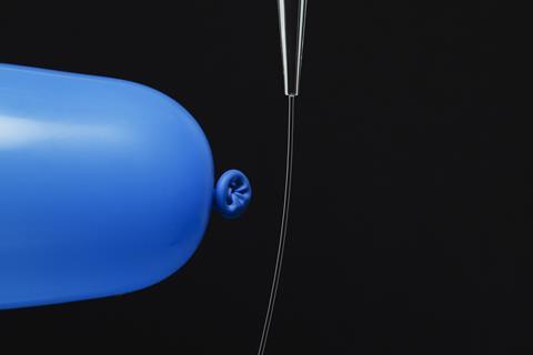 A photo of a charged balloon deflecting a water stream