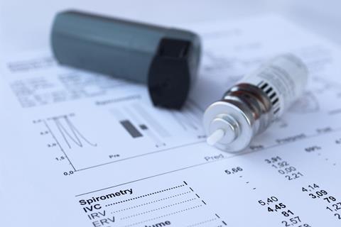 Plastic inhaler casing and metal cannister on a piece of paper