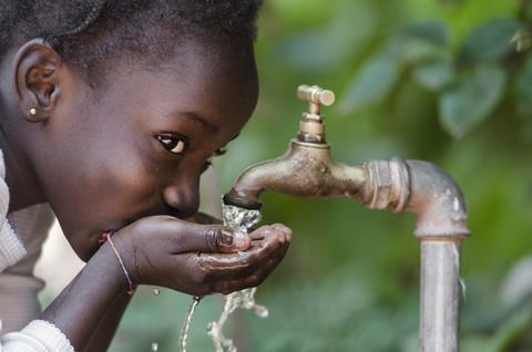 An African child drinking from a tap