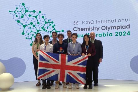 Students and mentors with a British flag at the 56th International Chemistry Olympiad in Saudi Arabia