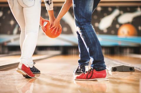 A couple bowling together