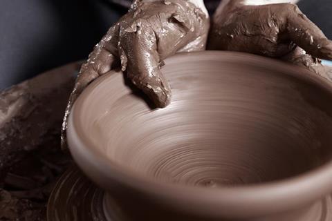 Working clay on a pottery wheel