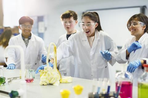 Surprised students conducting exploding foam scientific experiment in classroom laboratory